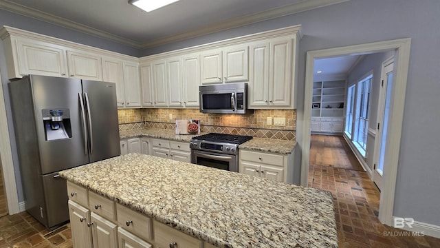 kitchen featuring decorative backsplash, light stone countertops, ornamental molding, and appliances with stainless steel finishes