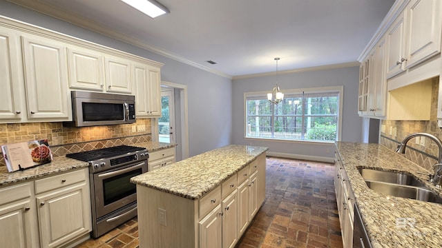 kitchen with backsplash, crown molding, sink, and stainless steel appliances