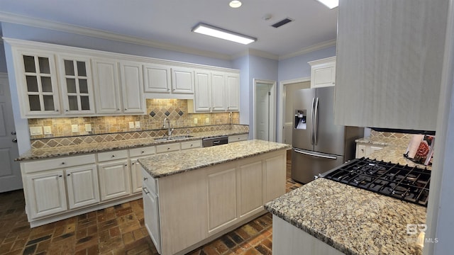 kitchen featuring a center island, backsplash, sink, white cabinetry, and stainless steel appliances