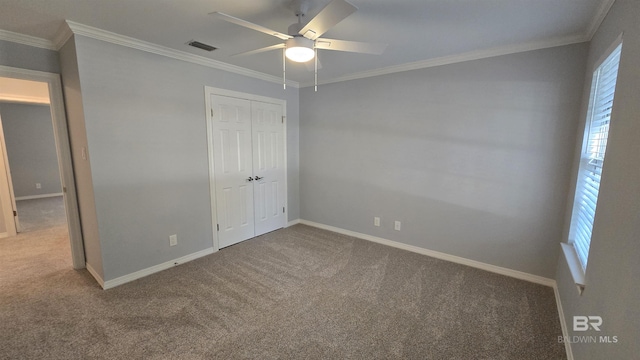 unfurnished bedroom with carpet flooring, ceiling fan, crown molding, and a closet