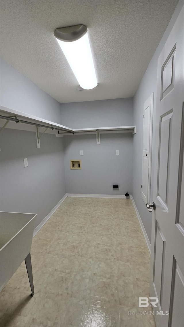 laundry room featuring a textured ceiling and hookup for a washing machine