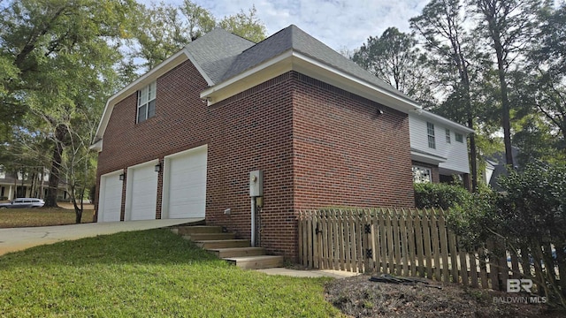 view of side of home featuring a yard and a garage