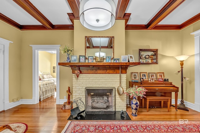 living room featuring beam ceiling, a fireplace, ornamental molding, and hardwood / wood-style floors