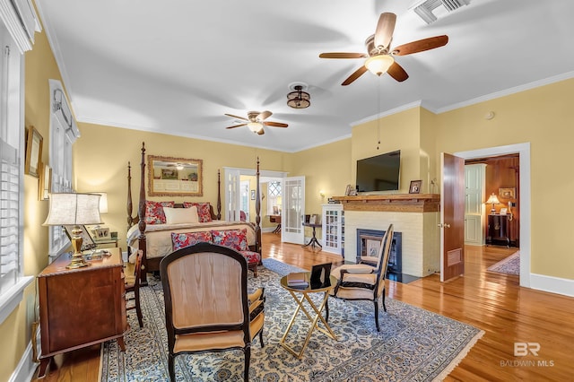 bedroom with wood-type flooring, a fireplace, and ornamental molding