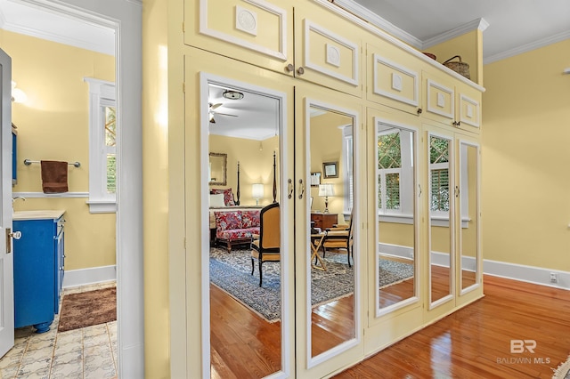 doorway to outside featuring light hardwood / wood-style floors, sink, ceiling fan, and crown molding