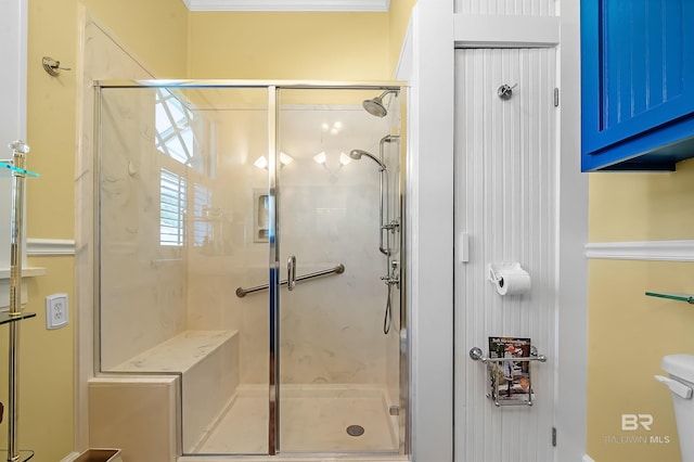 bathroom featuring a shower with door and toilet