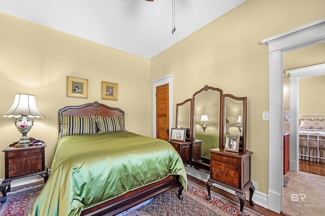 tiled bedroom featuring ceiling fan