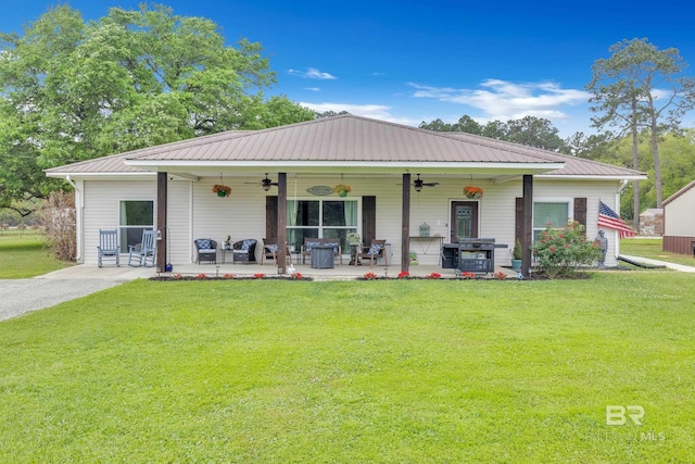 rear view of house featuring a yard, metal roof, ceiling fan, and a patio area