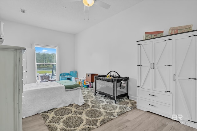 bedroom featuring ceiling fan, light wood finished floors, and visible vents