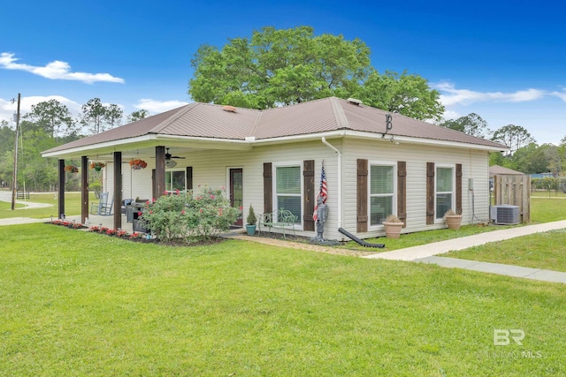 view of front of home with central AC unit, ceiling fan, metal roof, and a front lawn