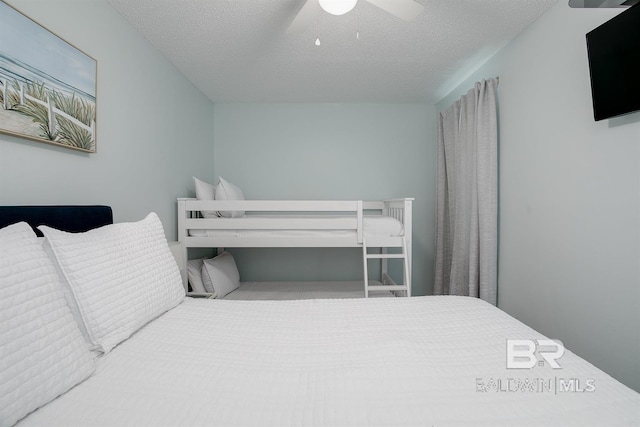 bedroom with a textured ceiling and a ceiling fan