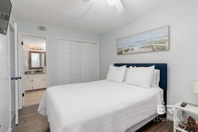 bedroom featuring wood finished floors, visible vents, ceiling fan, a closet, and a textured ceiling