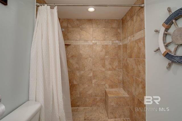 bathroom with a tile shower, recessed lighting, and toilet