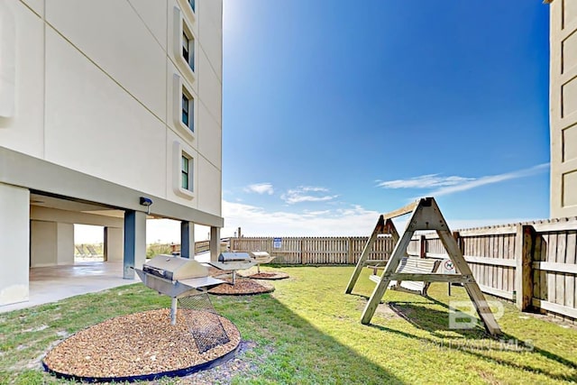 view of yard with a patio, a playground, and a fenced backyard