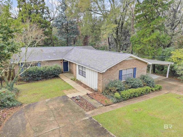 ranch-style home with driveway, a shingled roof, a front lawn, a carport, and brick siding