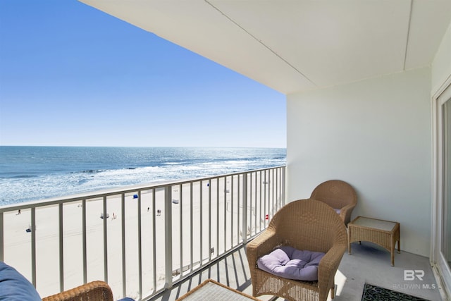 balcony featuring a water view and a beach view