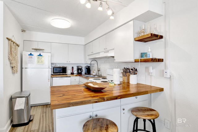 kitchen featuring open shelves, white appliances, butcher block countertops, and a peninsula