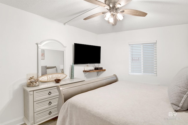 bedroom featuring ceiling fan and a textured ceiling