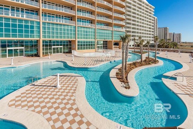 community pool with a view of city and a patio area