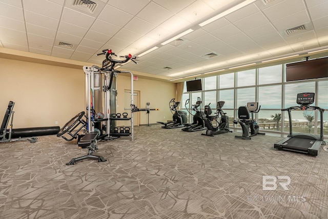 exercise room with a paneled ceiling and visible vents