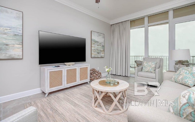 living room with ornamental molding, baseboards, and a ceiling fan