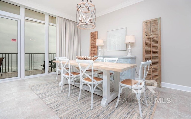 dining room with ornamental molding, a chandelier, and baseboards