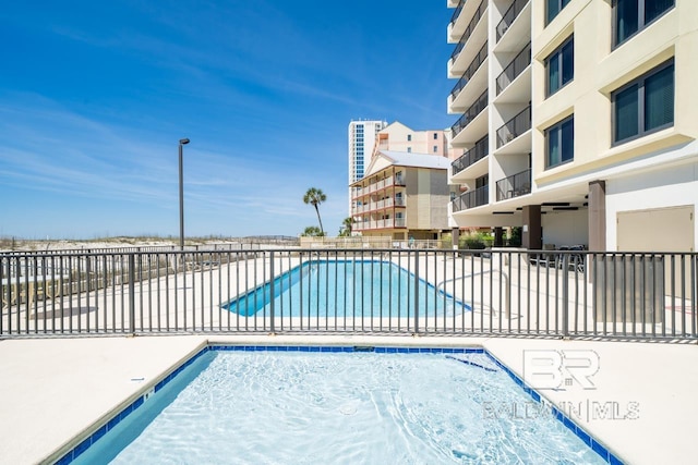 community pool featuring a patio and fence