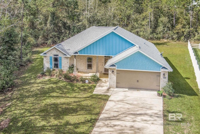 view of front of house with a front lawn, brick siding, a garage, and driveway