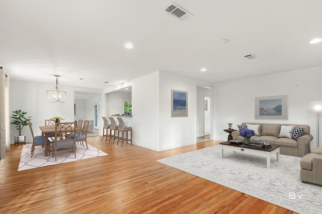 living room with a chandelier and light hardwood / wood-style floors