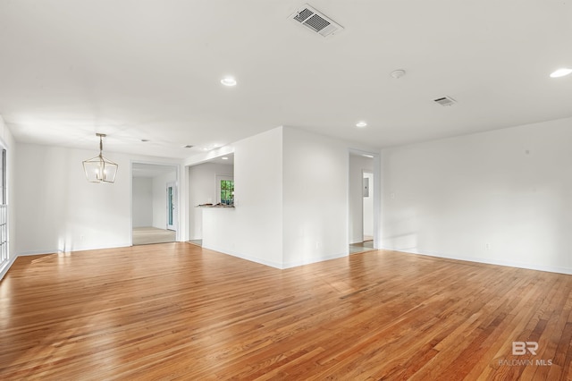 spare room featuring light hardwood / wood-style flooring and a chandelier