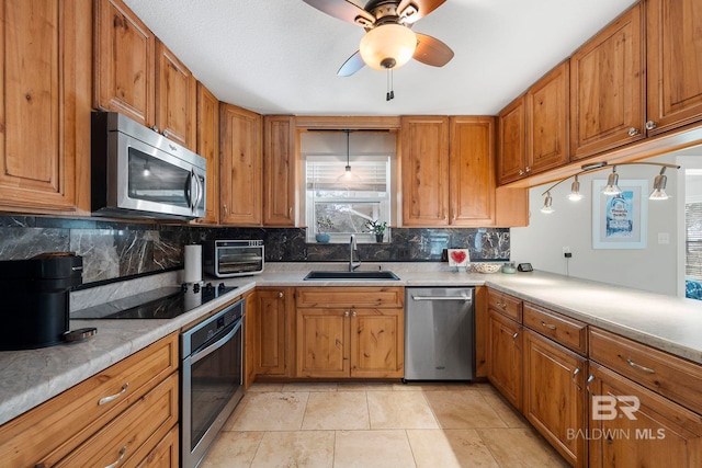 kitchen featuring sink, decorative backsplash, stainless steel appliances, and ceiling fan