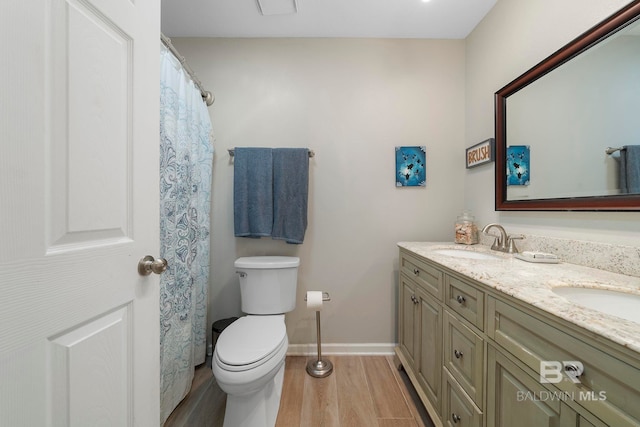 bathroom with vanity, toilet, and hardwood / wood-style floors