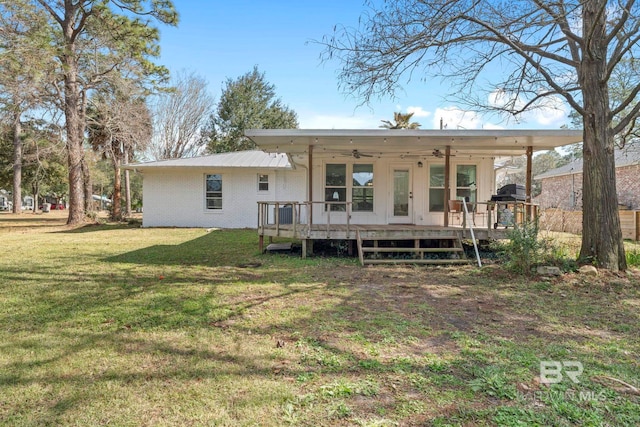 back of property featuring a wooden deck, ceiling fan, and a yard