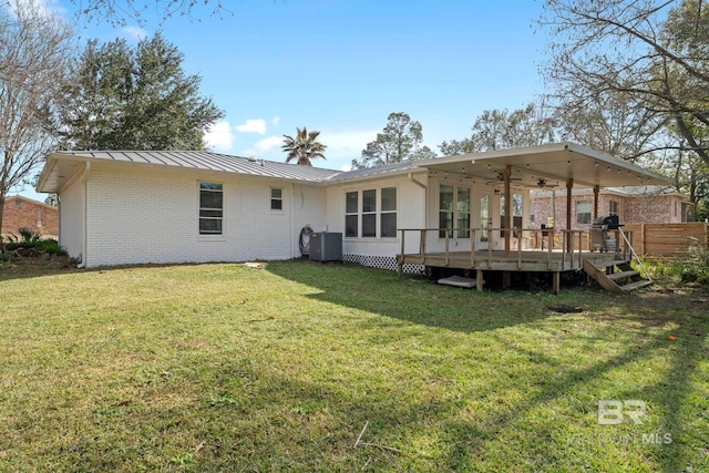 rear view of house featuring cooling unit, a lawn, ceiling fan, and a deck