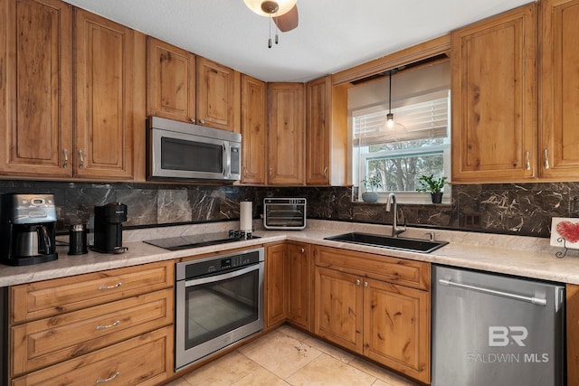 kitchen with tasteful backsplash, sink, decorative light fixtures, and stainless steel appliances