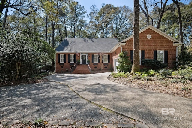 single story home with a garage, brick siding, and driveway