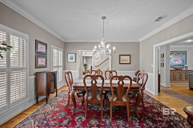 22649 Alice Ln, Fairhope, AL 36532 - dining room featuring a notable chandelier, visible vents, light wood-type flooring, and ornamental molding