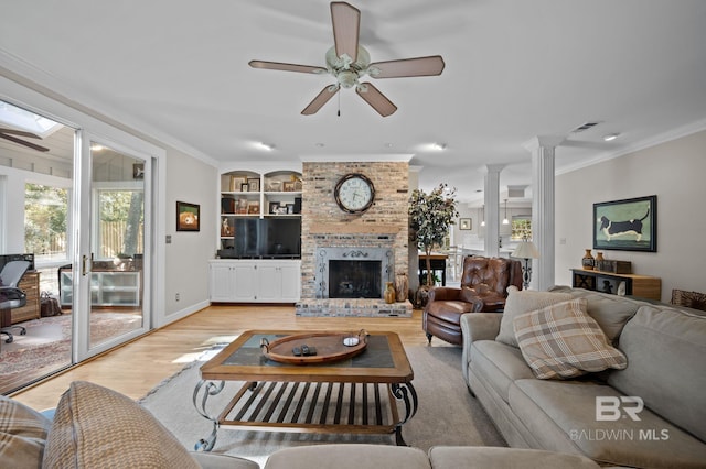 22649 Alice Ln, Fairhope, AL 36532 - living room featuring visible vents, light wood-style flooring, decorative columns, a fireplace, and crown molding