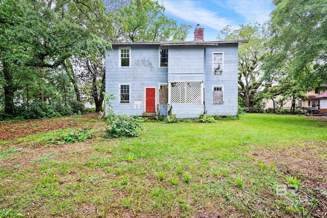 back of property with a lawn