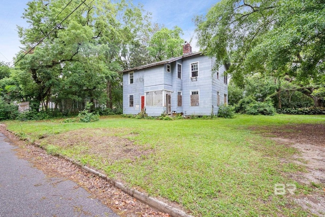 colonial-style house featuring a front lawn