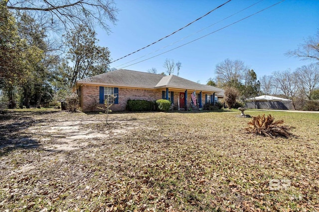 ranch-style home with a front yard and brick siding