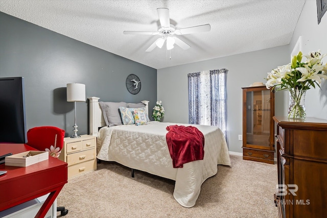 bedroom featuring carpet flooring, a textured ceiling, and ceiling fan