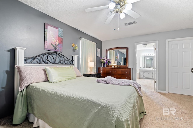 carpeted bedroom with a ceiling fan, baseboards, visible vents, a textured ceiling, and connected bathroom