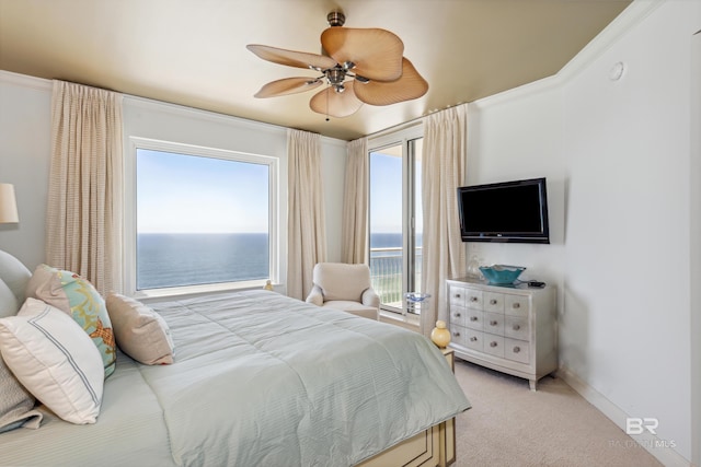 carpeted bedroom with ceiling fan, a water view, and access to exterior