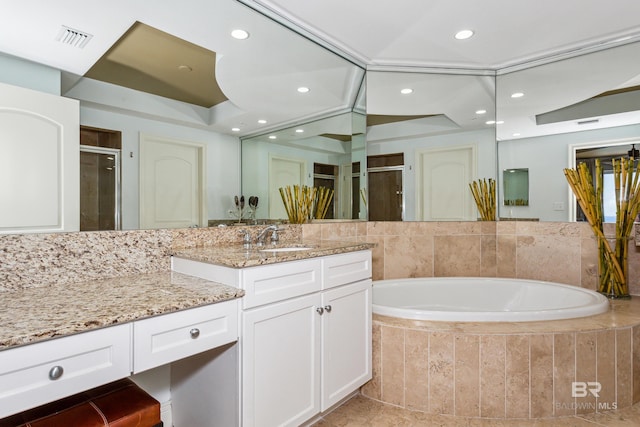 bathroom featuring tiled bath, tile floors, and large vanity