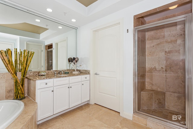 bathroom with tile flooring, a tray ceiling, vanity, and plus walk in shower