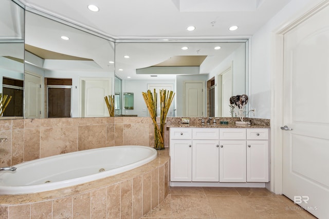 bathroom with tile floors, a relaxing tiled bath, vanity, and a raised ceiling