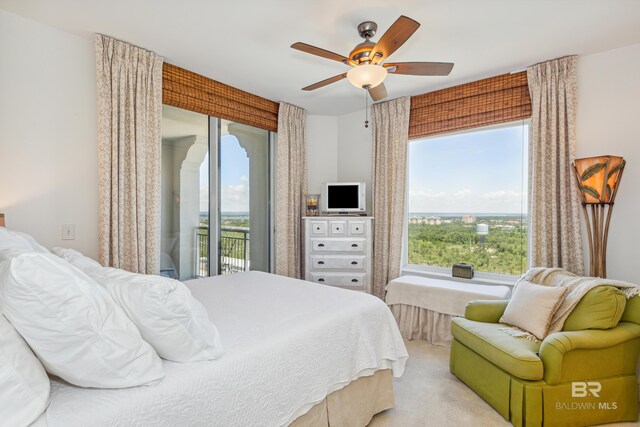 bedroom featuring light colored carpet, ceiling fan, access to outside, and multiple windows