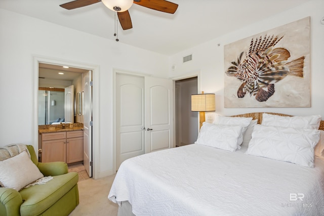 bedroom with ceiling fan, a closet, light carpet, ensuite bath, and sink