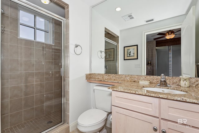 bathroom featuring a shower with door, ceiling fan, toilet, and large vanity